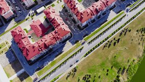 Top view of modern complex of houses with red roofs. Clip. Expensive multi-storey buildings located outside city. Complex of houses with red roofs