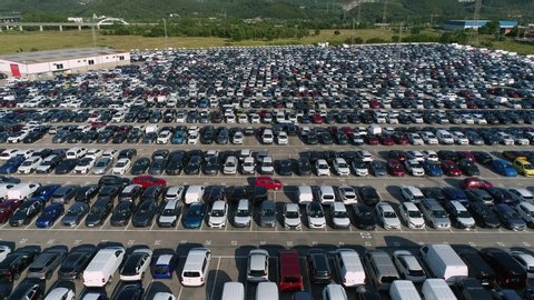 Fly back drone flies shot over huge parking lot for second hand (used) cars. Logistics transit.