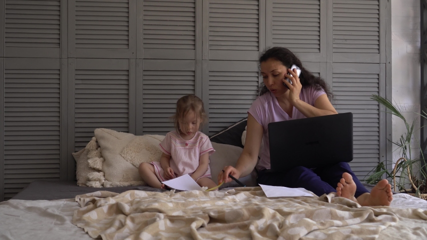 Remote Job multi-tasking mother with child. Stressed woman with laptop computer and papers working at home office Royalty-Free Stock Footage #1057865941