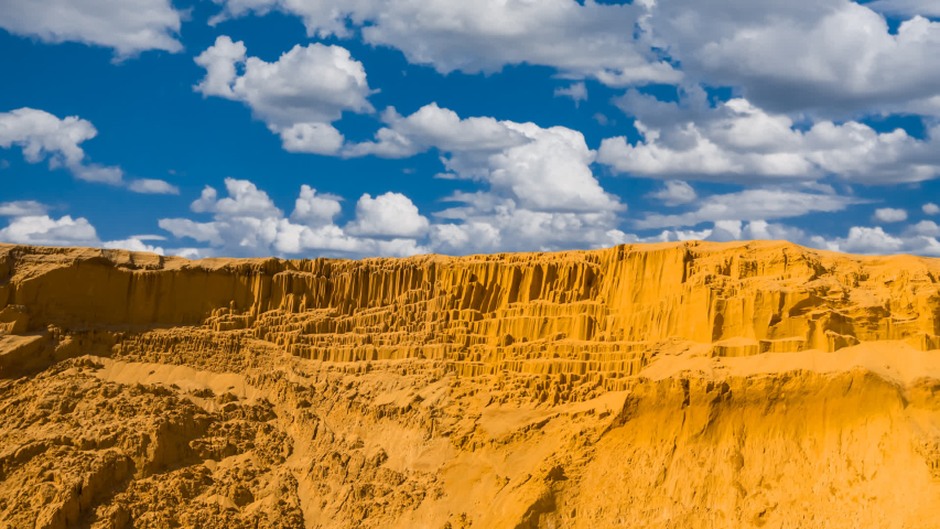sandy desert wall under a blue cloudy sky