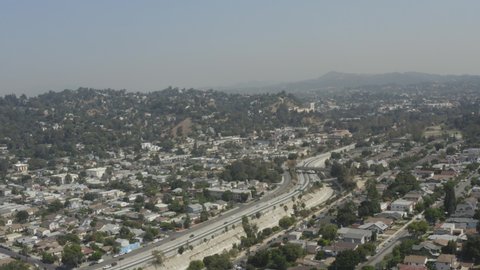 Aerial over residential neighborhood in urban sprawl metropolis. Busy Los Angeles highway through suburban area in California. 4k drone flight video in West Coast USA