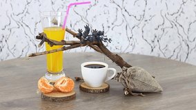 Coffee cup with bun and wooden branches on spinning wooden table background.