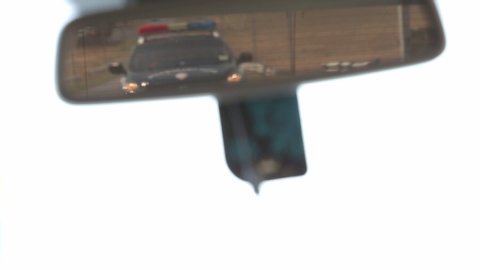 Police car in the side mirror chasing a car on highway. Police chase, the car is running away from the chase