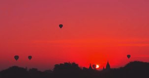 Sunrise in Bagan, Myanmar (Burma) with hot air balloons flying over ancient temples. Timelapse video