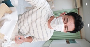 vertical video of smartphone simulation asian young male patient wear facial mask and describe health condition to the doctor