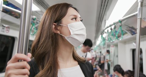 Asian businesswoman with surgical mask face protection and keep social distance while commute in the metro or train mrt