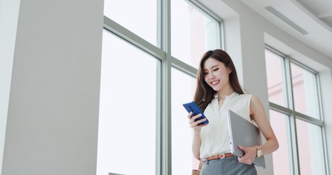 asian young businesswoman use smart phone with laptop on her business trip