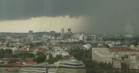 Dramatic Time Lapse of City Skyline surrounded by Heavy Rain coming into the City during Thunderstorm with clouds and fog in Berlin, Germany