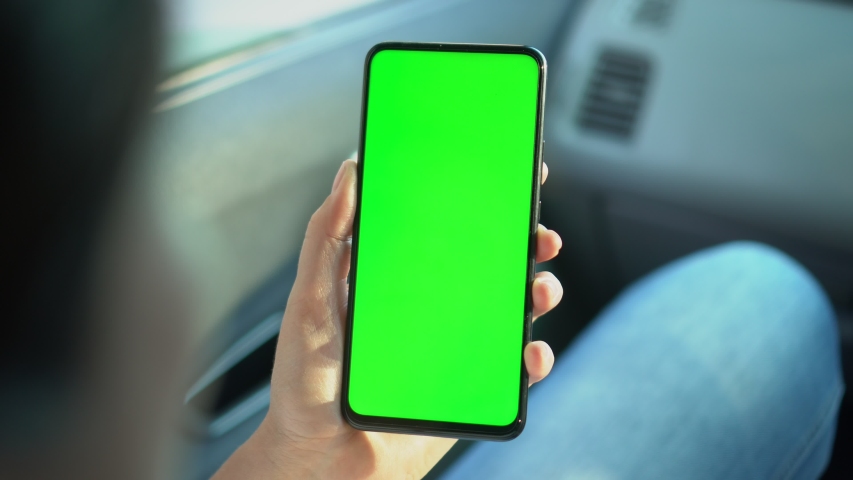 Close up of a woman's hand holding a mobile telephone with a vertical green screen in car chroma key smartphone technology cell phone street touch message display hand | Shutterstock HD Video #1057879306