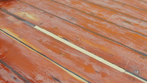 Rubbing hand across sanded wooden insert on boat wheelhouse cabin roof