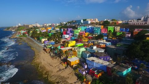 Aerial view of La Perla neighborhood in San Juan Puerto Rico during summer season. Sea waves beautiful beach colorful houses urban dangerous drug crime despacito music video filming location