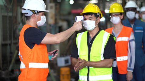 Head of industrial plant  using thermometer to check body temperatures Before going to work  COVID-19 prevention policy