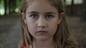 Portrait Little Child Girl Looking at Camera Standing on Street in City on Summer Day. Young Sad Thinking Curiosity Child Looking at Camera Closeup Outdoors. Face Eyes Serious Contemplative Child. - Powered by Shutterstock - Get 15% off with code: PIKWIZARD15