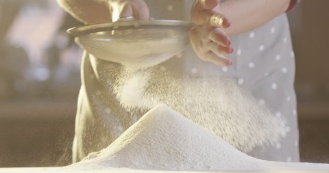 Woman Sifting Flour with a Sifter in the Kitchen with Sun Shining in Slow Motion Shot on Red Camera