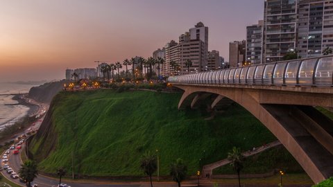 Villena Bridge with traffic and partial City view in the Background day to night transition timelapse, Lima, Peru. Aerial view with illuminated coastline and Love park