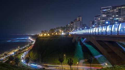 Villena Bridge with traffic and partial City view in the Background night timelapse hyperlapse, Lima, Peru. Aerial view with illuminated coastline and Love park