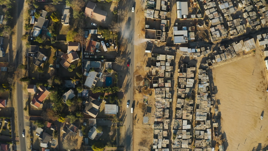 Inequality.Aerial close-up straight down view of an informal settlement Kya Sands squatter camp right next to middle class suburban housing, Gauteng Province, South Africa Royalty-Free Stock Footage #1057903051