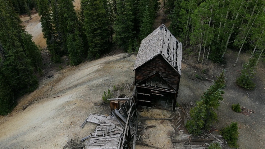 Aerial view Ascending shot, Scenic view of Abandoned Mining House on the top of Mountain In Uncompahgre National Forest, Pine Trees in the background.