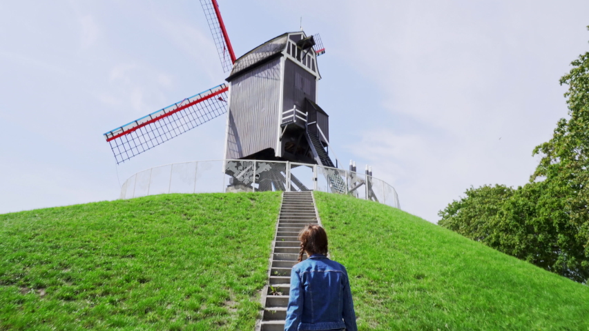 A young woman climbs the windmill
