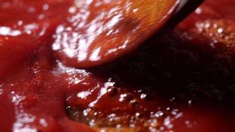 Close-up of boiling red tomato sauce in a pan with steam for making pizza or pasta