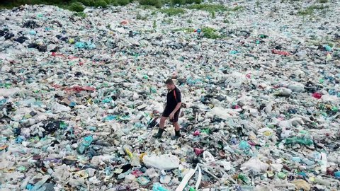 A man walks through a landfill and studies its level of danger. The concept of environmental pollution and environmental catastrophe