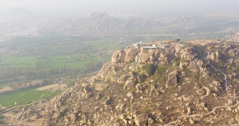 Aerial view of anjanadri hill, rocky mountain with green rice fields, Hampi, India