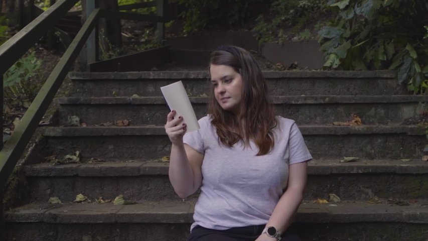 Woman reading a book and enjoying the leisure in an open-air space