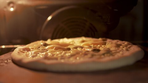 Timelapse of a pizza being cooked in the oven. Close-up melting cheese in 4K.