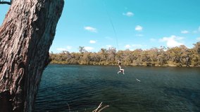 Rope swing jump girl summertime. Girl swings on rope swing into beautiful lake - Powered by Shutterstock - Get 15% off with code: PIKWIZARD15