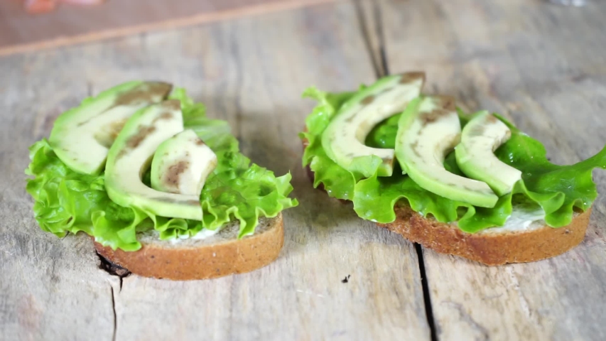 A close up of a sandwich sitting on top of a wooden cutting board | Shutterstock HD Video #1057936477