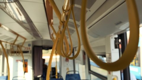 Hanging handrails in a bus. Plastic yellow grip on strap in public transport passengers. Tram or subway handrails 4k