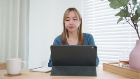 Beautiful Young Asian businesswoman in casual clothes
making video call conference talking, discussing with team or colleagues, online meeting communicating by tablet webcam. remote working concept.