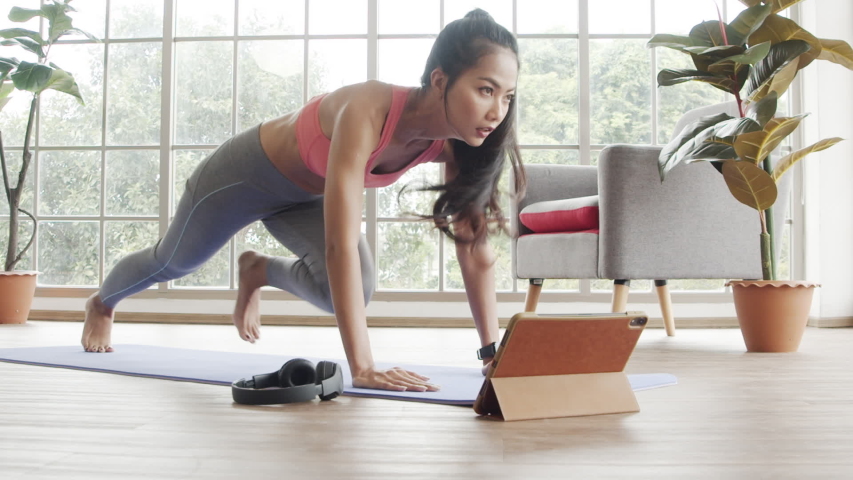 Beautiful asian female doing plank exercise training in the living room at home during the quarantine.