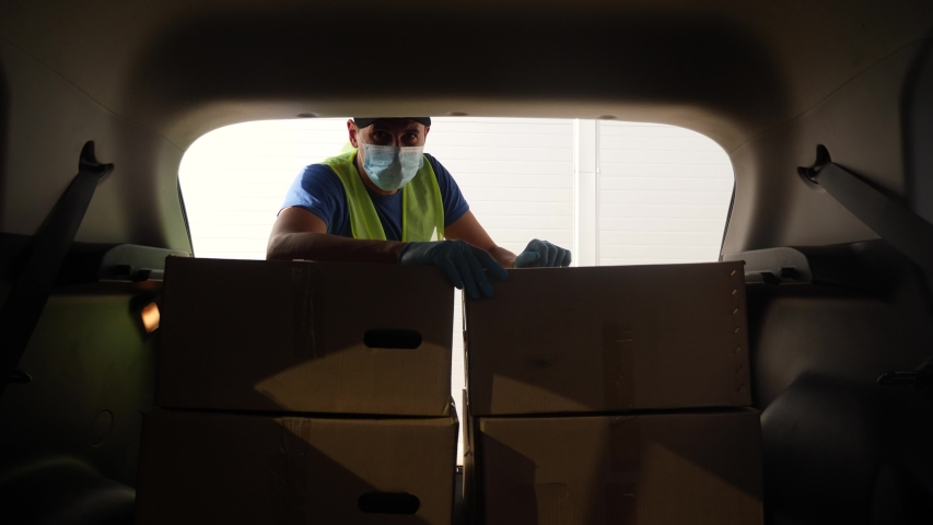 driver worker coronavirus. loader wearing a medical mask delivers goods during the coronavirus period. driver worker coronavirus. courier driver in gloves loads boxes during coronavirus Royalty-Free Stock Footage #1057955194