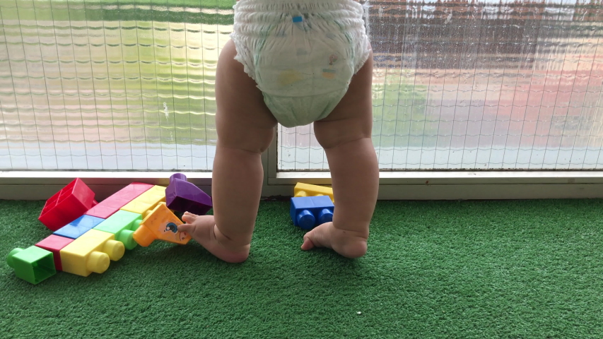 Baby in diaper learning to walk