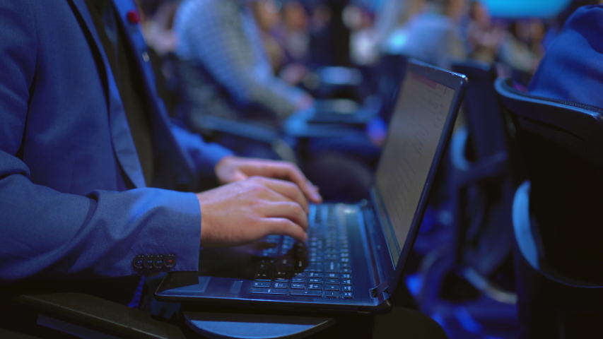 Person type keyboard crowded audience business forum. Viewer seminar listen speaker auditorium. Business man typing notebook political summit. Group people learning education speech in crowd audience