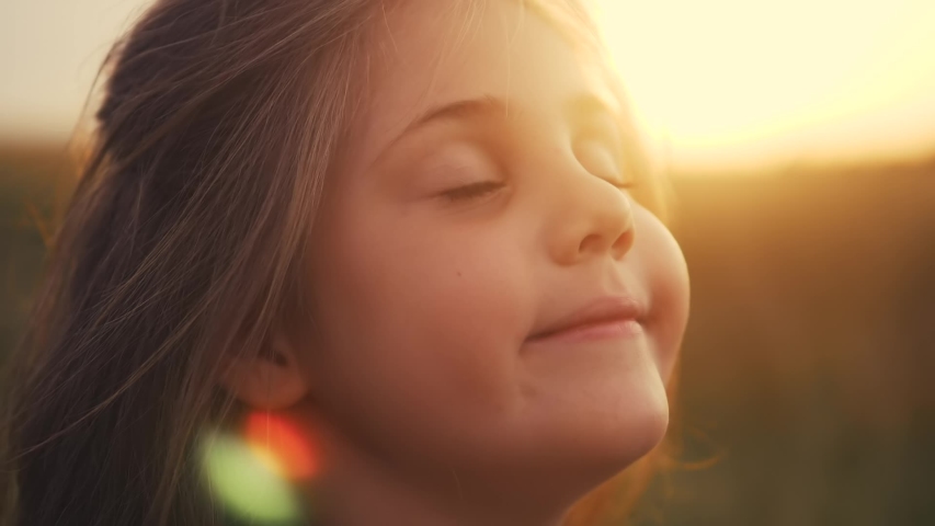 Happy little girl child closed her eyes dreams. kid wants a dream come true portrait at sunset. baby daughter silhouette dreaming of a happy childhood. free face sister side lifestyle view thinks | Shutterstock HD Video #1057965817