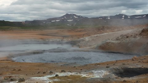 Steaming and bubbling mud pool in the Hverir geothermal area located near lake Myvatn in Iceland. Hverir area is driven by volcanic activity and is a famous tourist destination. 4K UHD video.