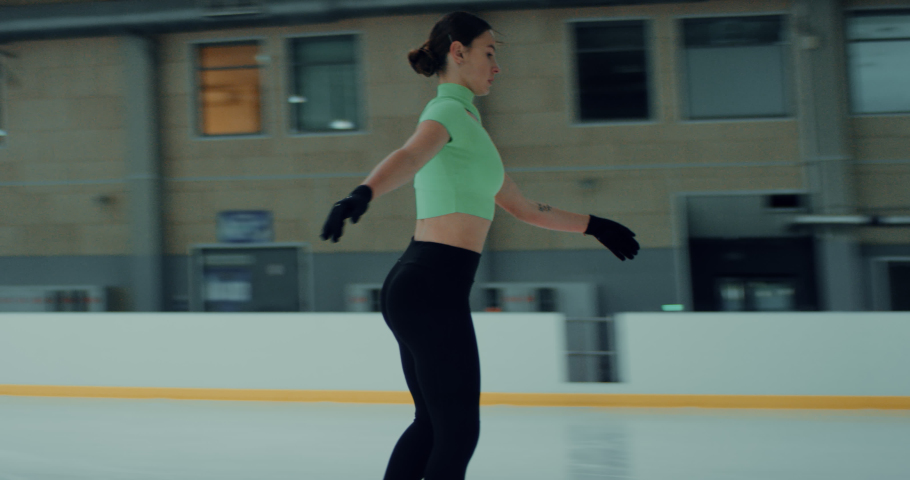 Female ice figure skater falls on ice while practicing jumps on the rink. Shot on RED cinema camera with 2x Anamorphic lens Royalty-Free Stock Footage #1057976695