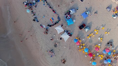 Colourful sea beach on a hot summer day, aerial drone view 4k