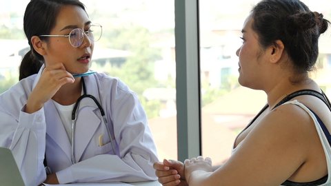 the young female medical doctor gave advice to a fat overweight Asian woman for weight loss and a healthy lifestyle to prevent illness from the COVID-19 coronavirus pandemic.