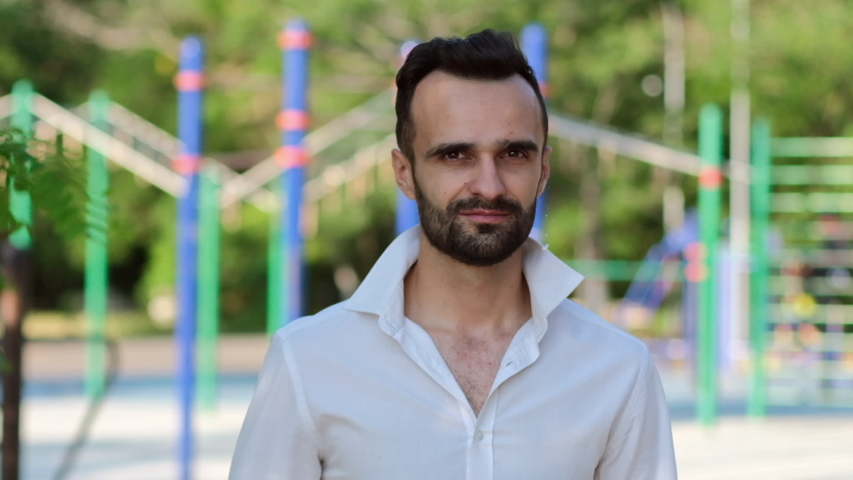 A portrait of a man in a white shirt, on whose head the water is being poured, refreshing him on a hot summer day. Slow motion at 120 fps.