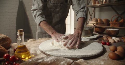 Closeup shot of hands of experienced chef working at bakery, sifting flour through sieve. Old man making traditional homemade bread - food and drink, hobby concept 4k footage