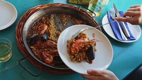 Delicious seafood paella - savory rice dish with shrimps and clams served in traditional spanish paella pan