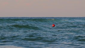 Buoy float on the sea water. Sunrise waves toward beach