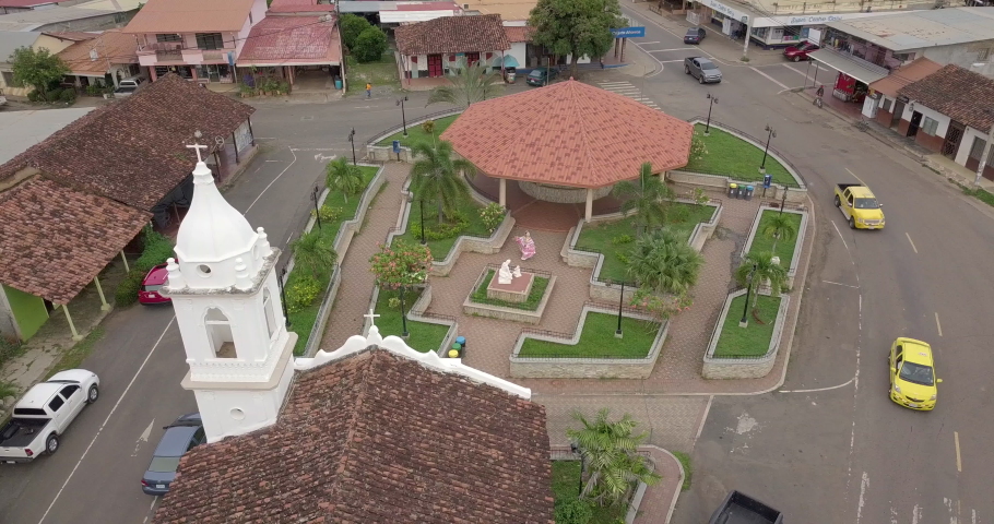 Aerial shot of church and a park in a small rural town with a panamanian pollera, orbit aerial shot. part1