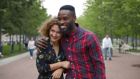 Beautiful diverse young couple in love walking in summer park. African man hugging smiling caucasian girlfriend walking together in city park enjoying romantic date - Powered by Shutterstock - Get 15% off with code: PIKWIZARD15