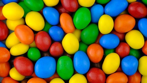 Candy sweets background. Assorted colorful chocolate candies. Colorful delicious sweets turning top view.