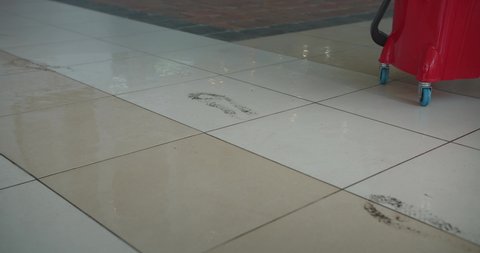 Man in the white sneakers leave a dirty footsteps on the floor in the mall