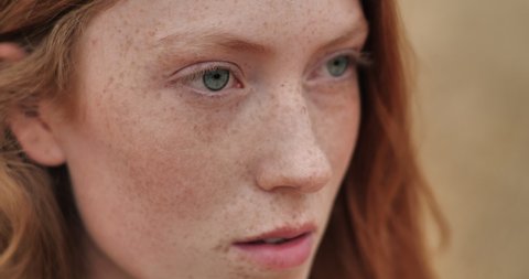 Close up of Woman’s Face, Girl opening her Beautiful blue Eyes, Attractive Ginger. Natural Beauty with Freckles. Gorgeous woman with long Eyelashes and Attractive Appearance. Slow motion.